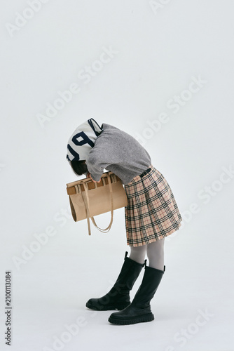 手作りのダンボールのバッグを持ってポーズをとる女の子