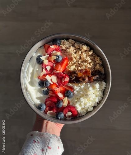 Nutritious oatmeal bowl topped with fresh strawberries, crunchy granola and seeds. A healthy breakfast rich in fiber and vitamins, beautifully presented for wellness, diet and clean eating concepts.