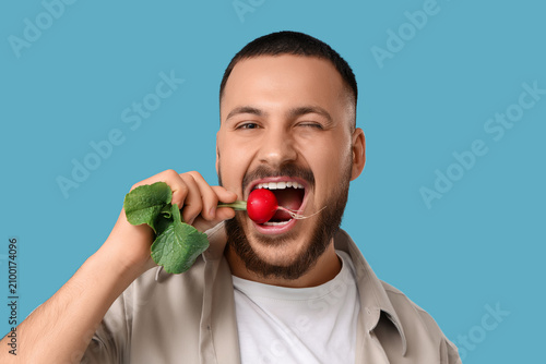 Young man eating ripe radis...