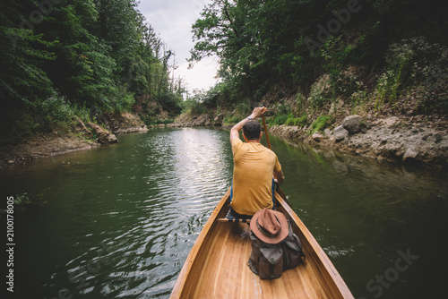 Adventurer paddling canoe through lake