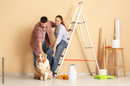 Canvas-taulu Young couple with cute dog and equipment during repair of their new house
