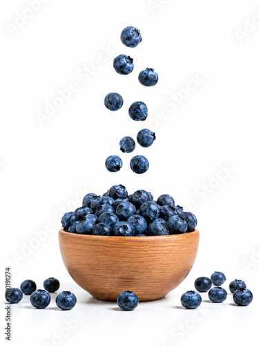 Fresh Blueberries Falling into a Wooden Bowl