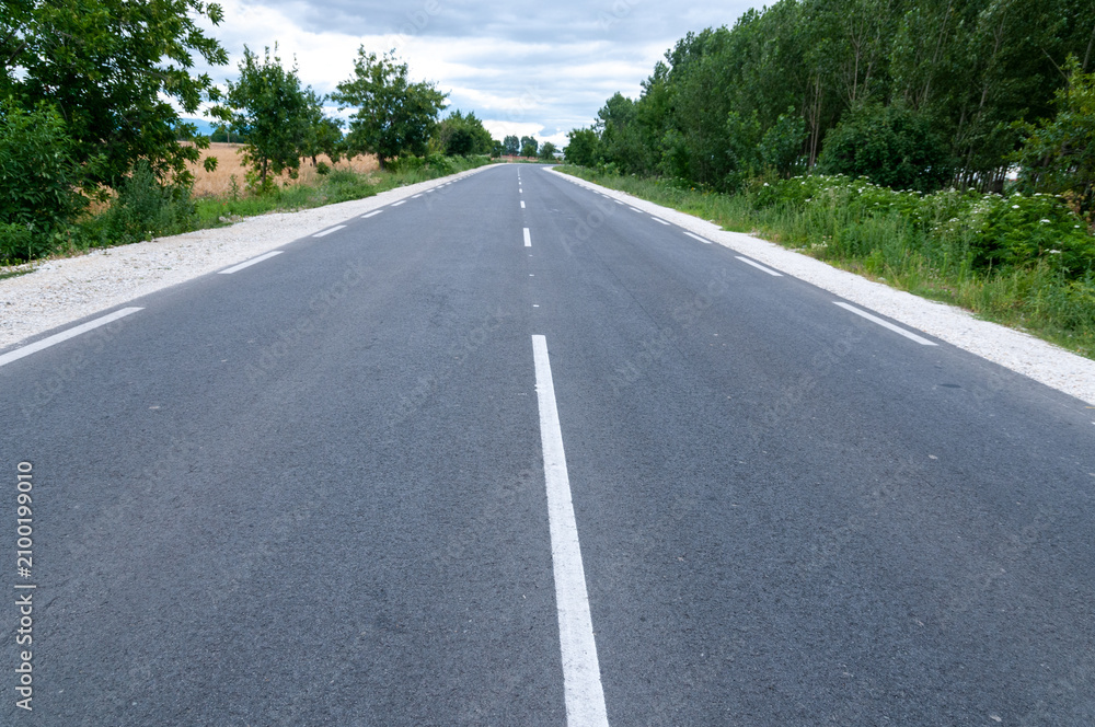 Fototapeta premium New Empty Asphalt Highway Through Rural Countryside Under Clear Blue Sky