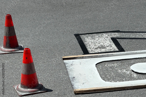 Road worker painting speed limit 20 marking on asphalt street
