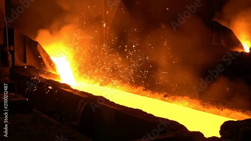 Molten Metal Pouring Sparks in Industrial Furnace Environment Creating Intense Manufacturing Atmosphere