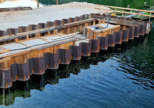 sheet pile cofferdam made of steel piles. Construction Detail Material structure consists of interlocking steel profiles known as Larssen sheet piles. These are driven deep into river 