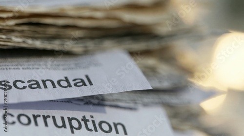 Elegent photo of Close-up of printed words scandal and corruption on paper. Concepts of government misconduct, corporate fraud, and investigative journalism.