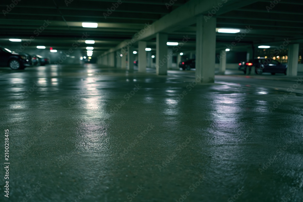 Obraz premium The Parking Garage Wet Floor at Night Dimly Lit Quiet and Reflective