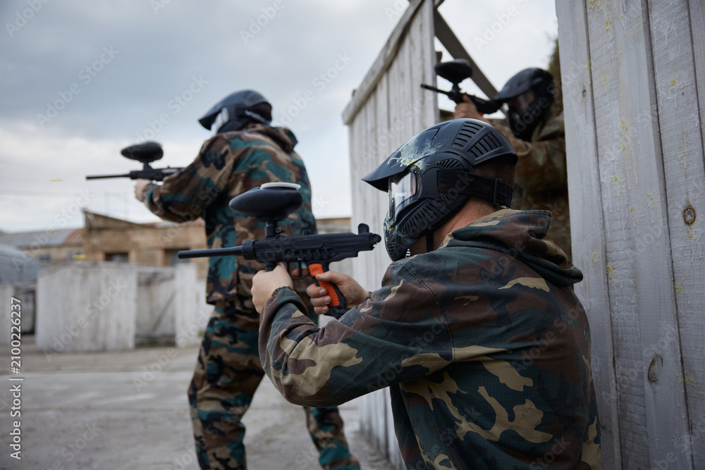 Fototapeta premium Two soldiers point their guns at a target on a training field