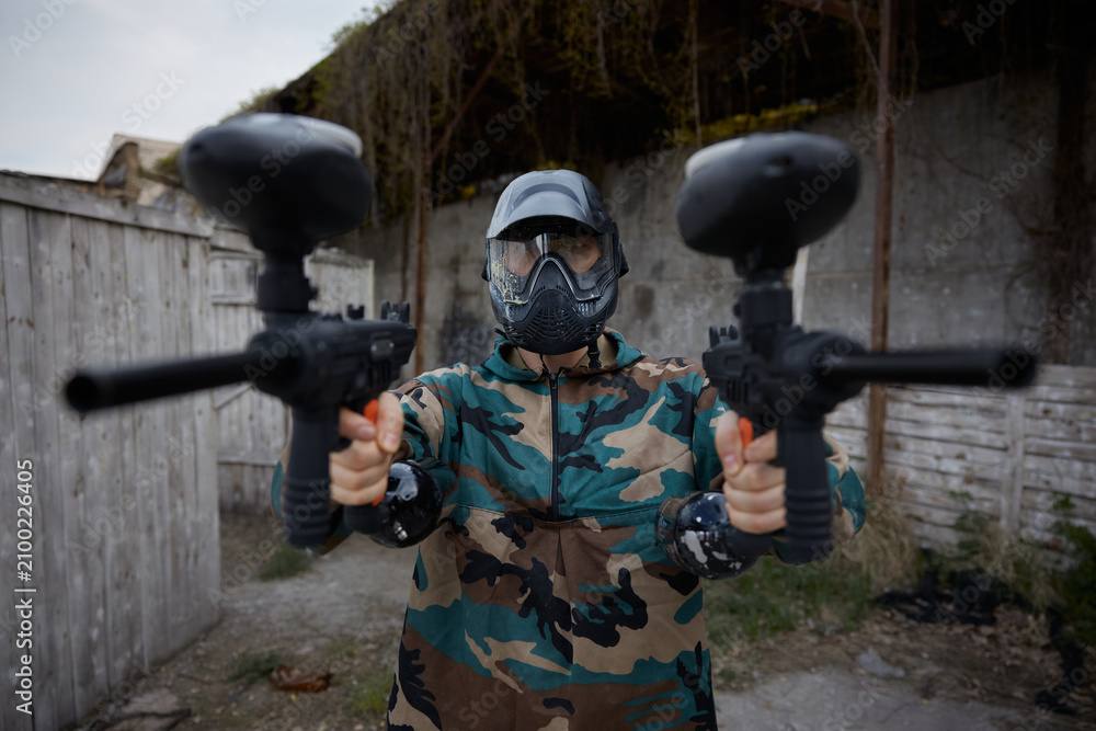 Fototapeta premium A portrait of well-armed and clothed soldier, holding one military gun in each hand