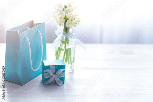 Gift Bag and Box with Spring Flowers on White Table