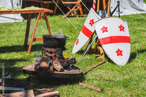 Foto An outdoor historical encampment features a cauldron cooking over a fire pit nex