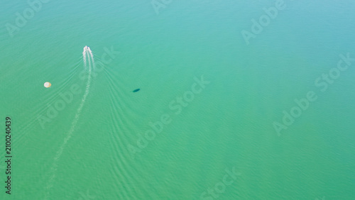 Photography Horizontal aerial view of a speed boat towing a white parasail with a distinct d