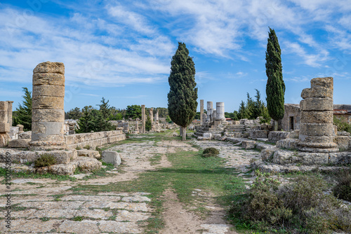 Ruins of ancient Cyrene show historic columns and pathways under a clear sky in Eastern Libya