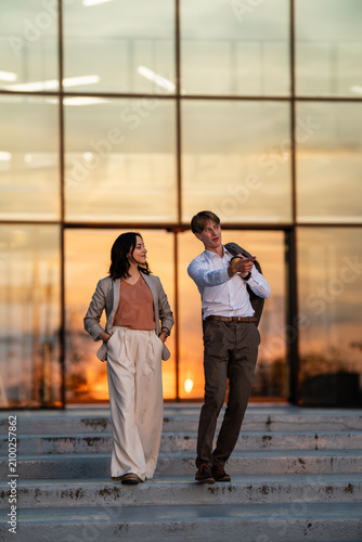 Business professionals communicating on steps at sunset