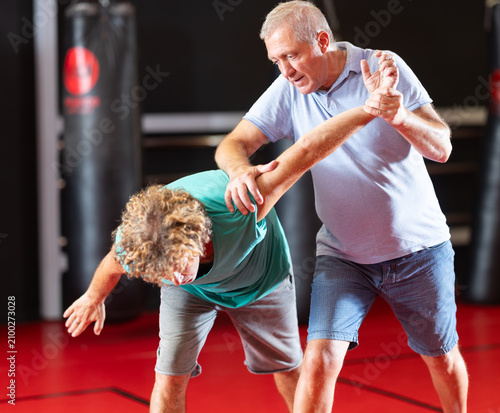 Foto Purposeful male pupil clash with training manager during self-defense lesson, re