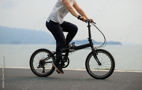 Riding folding bike on seaside road