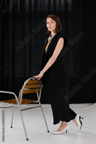 Canvas-taulu Stylish woman poses with poise in a chic outfit, emphasizing elegance and confid