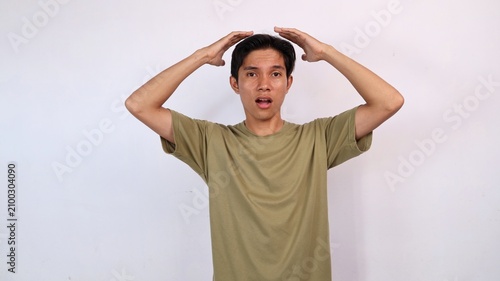 Photos shocked asian man holding head with hands