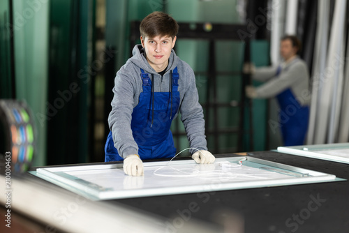 Konstfotografi Guy glazer employee in blue overall works in glass processing shop