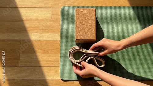 Yoga Stretching Techniques Demonstrated with Cork Block and Strap on Green Checkered Mat in Sunlight for Wellness and Fitness Concepts