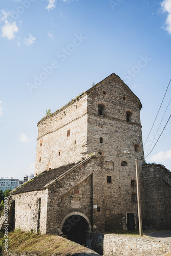 Ancient stone fortress tower with arched entrance under a clear blue sky
