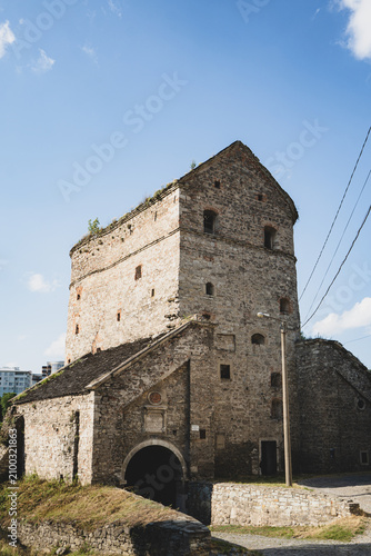 Ancient stone fortress tower with arched entrance under a clear blue sky