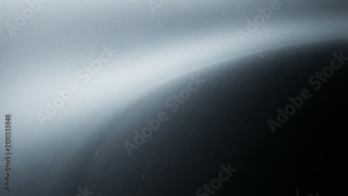 Abstract dark atmospheric background with soft glowing white light curve and subtle dust particles.