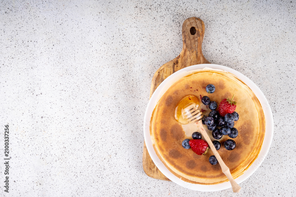 Fototapeta premium Homemade french tiny pancakes, crepes with berries and honey