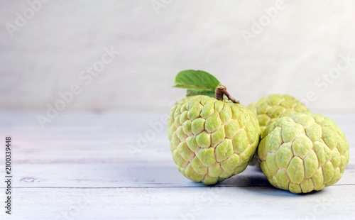 Fotografie Fresh Sugar Apple (Custard Apple) with Green Leaf on Wooden Table