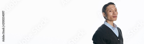Foto Young man exudes confidence in trendy clothing, posing gracefully in a minimalist setting
