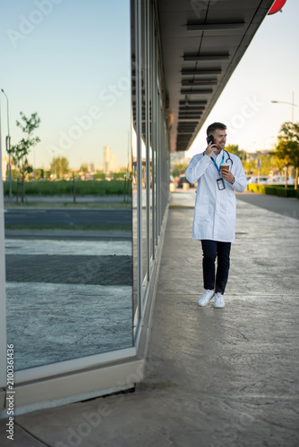 Healthcare professional walking outdoors talking on smartphone