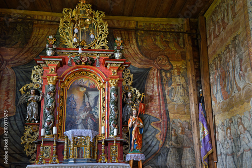 Inside St. Michael Archangels Church in Binarowa with ornate altar and wall paintings