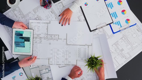 Architects and engineers create a construction blueprint for a modern building, reviewing errors and suggestions during a collaborative boardroom task.