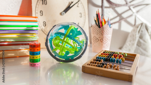 Konstfotografi Various educational toys and learning supplies on table: spherical puzzle, wooden abacus, stack of books, math learning cube