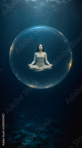 Yoga in the lotus position. Young woman in air bubble in deep blue sea. Deep meditation diving. Zen concept. Meditating girl. Spiritual lifestyle. 