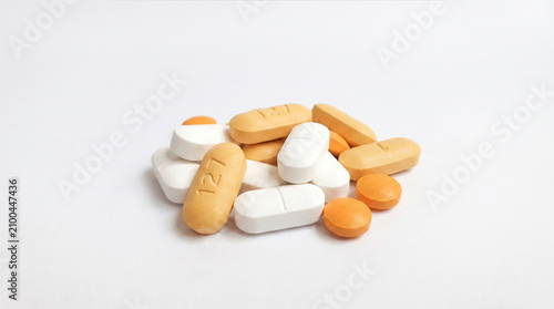 Canvastavla closeup photo of group of white and yellow color pills on isolated white backgro