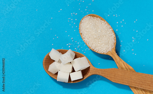 Картината върху платно Wooden spoons with different types of white sugar granulated sugar and cubes on