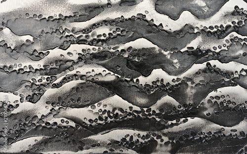 Close-up of the forged steel texture on a knife blade with a raised dark pattern.