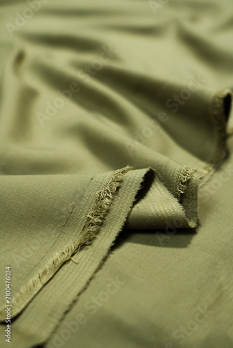 Soft olive green fabric material with natural draped folds material background cascading