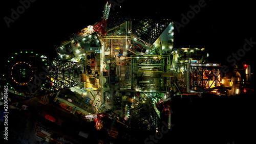 Cuadro en lienzo Oil Drilling Rig Dominates Dark Industrial Landscape at Night, showcasing coloss