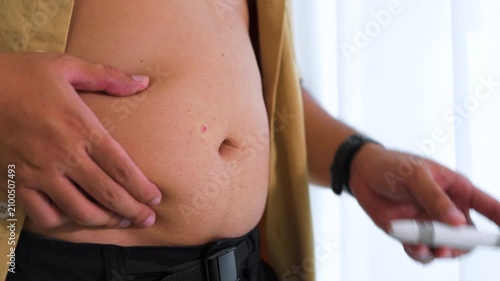 Close-up of a man injecting a weight loss pen into his abdomen for diet control. Concept of obesity treatment, GLP-1 medication and slim body goals.