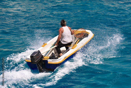 Un homme seul dans son bateau à moteur partant à la pêche