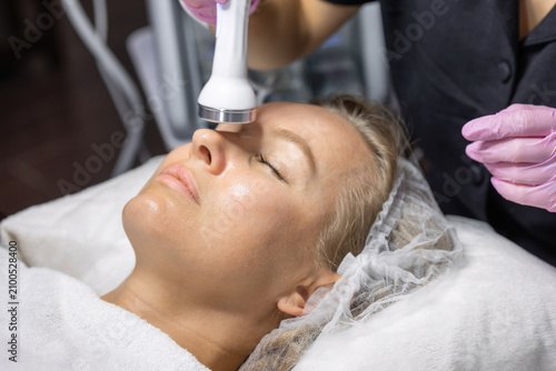 Принти на полотні Close-up of a cosmetic physician performing a radio frequency facial treatment on the nose area to stimulate collagen production, improve skin firmness and support noninvasive facial rejuvenation