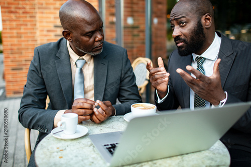 Two businessmen discussing strategy at outdoor cafe