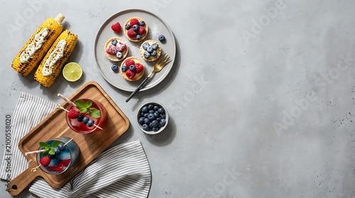 Flat lay of summer party food with grilled corn tarts and drinks