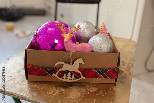 Colorful decorations in a box with a horse figure and a plaid ribbon for holiday events