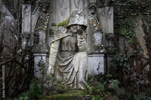 Fragment of an ancient, ruined tombstone. Mary in grief (concept: death, suffering, loss)