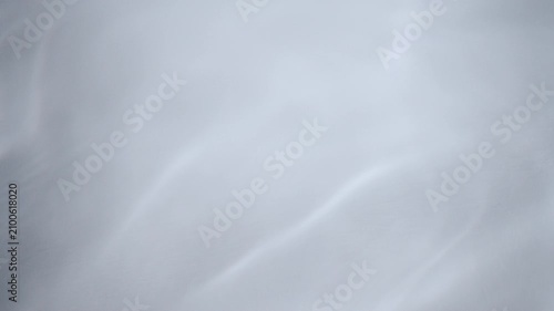 Water on white cosmetic backplate with smooth waves and rippled surface full frame wide shot. Concept 3D animation loop background. Beauty and health care copy space. Medical hygiene showcase backdrop