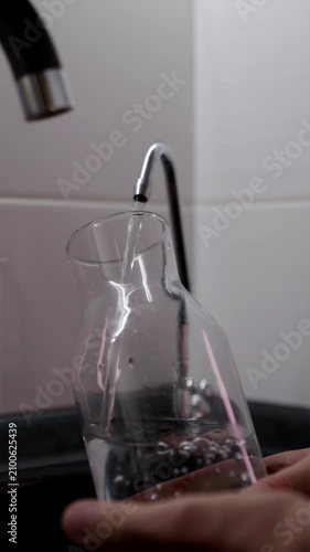 Filling reusable sports bottle with fresh filtered water vertical